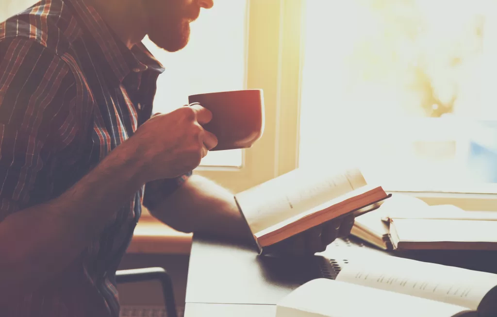 stock photo bearded man reading book with coffee