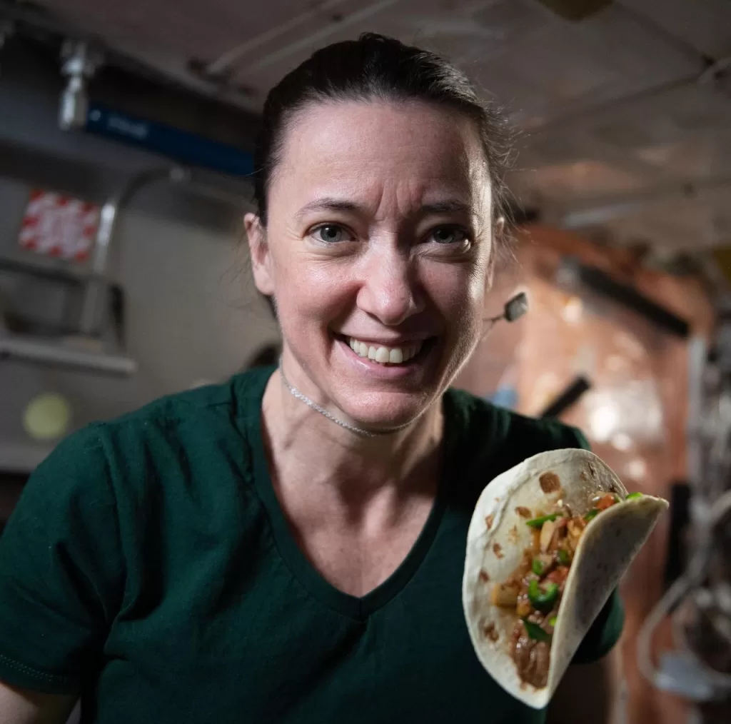 Astronaut Sandra Magnus on the ISS with a tortilla made using space-grown chilli peppers.